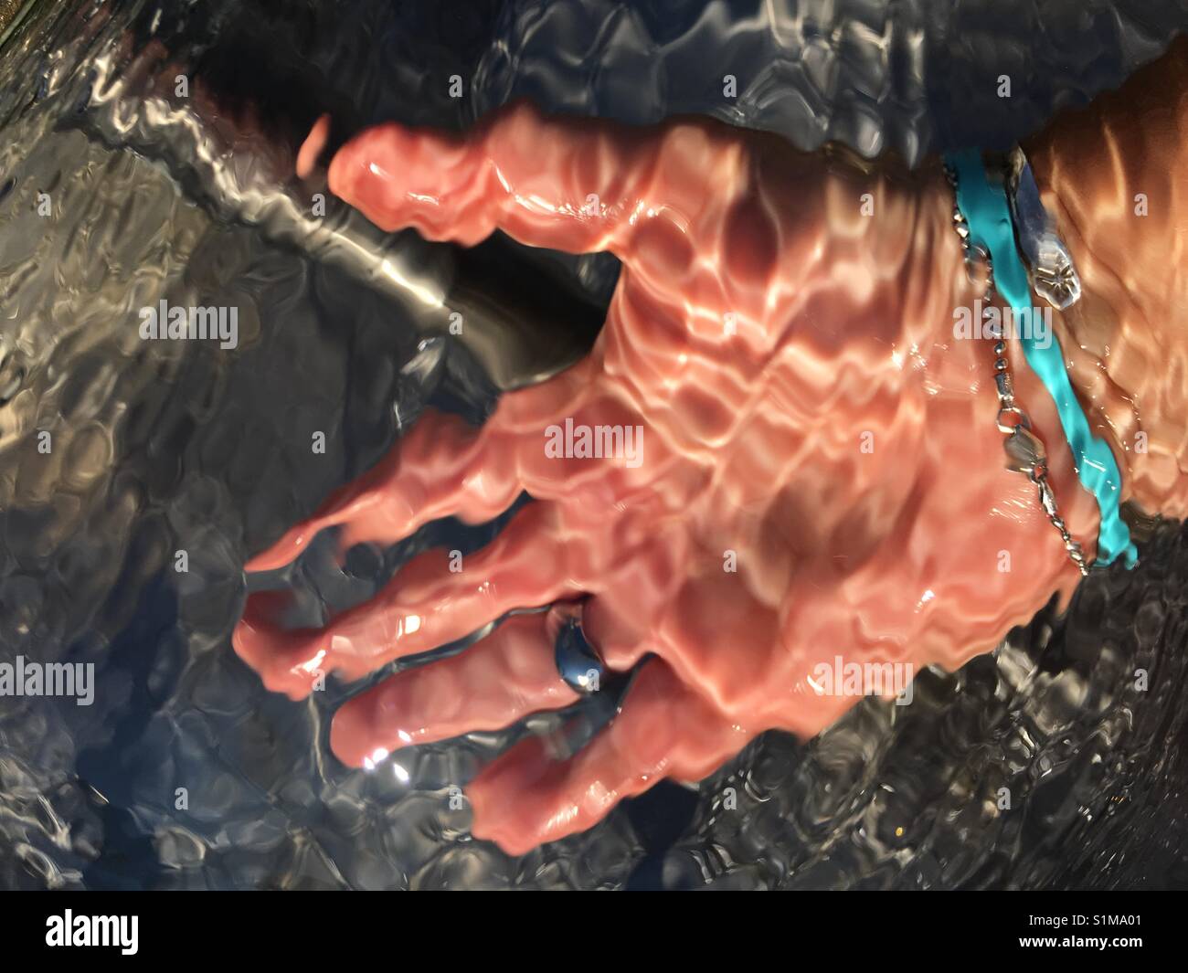 Hand durch Wasser Brunnen - Smartphone-aufgenommenes Stockfoto