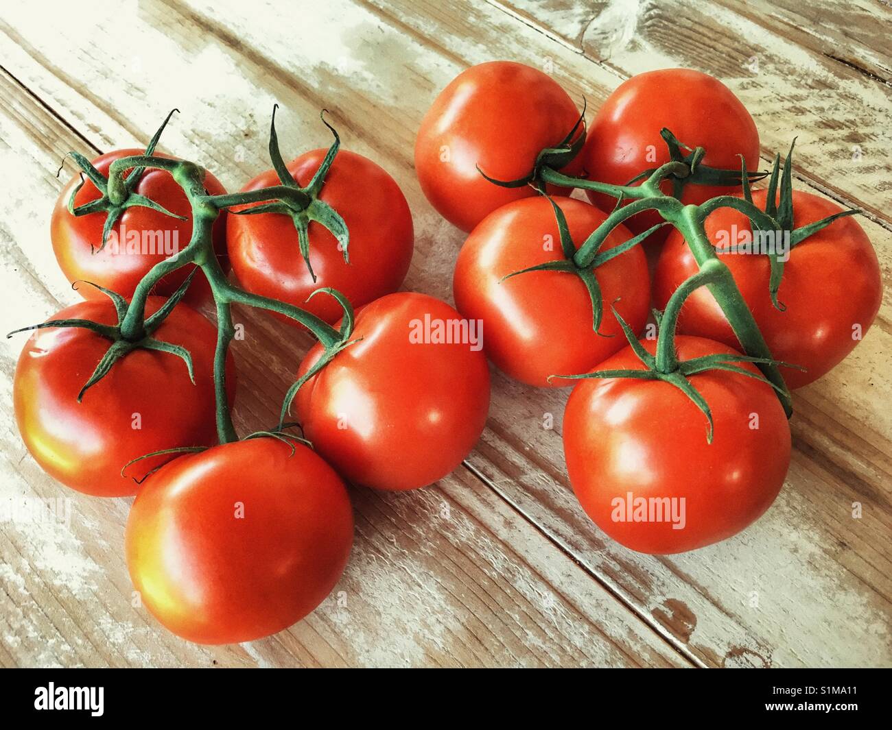 Strauchtomaten auf einem Holztisch - Smartphone-aufgenommenes Stockfoto