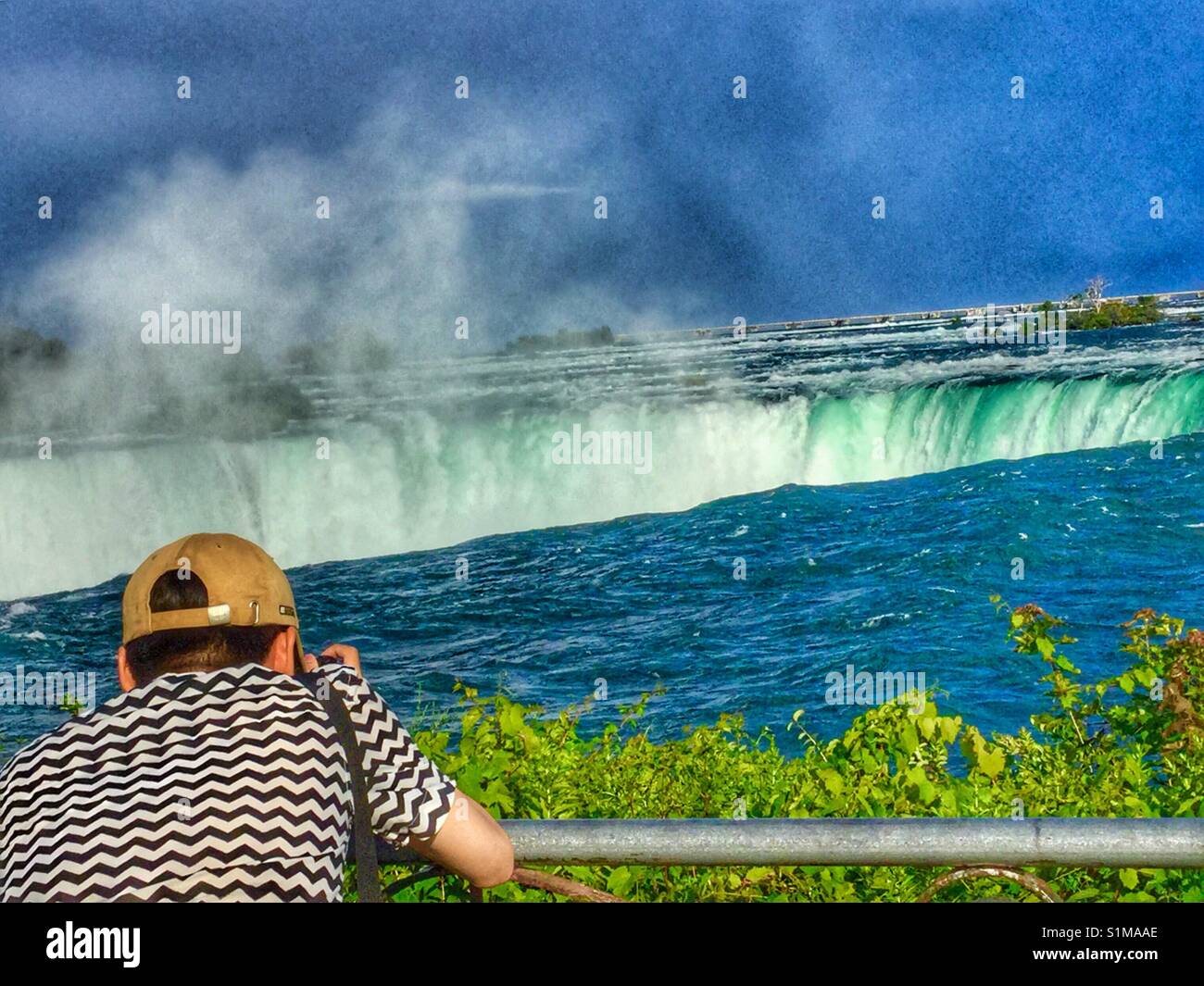 Männliche Tourist, Fotos der Horseshoe Falls. - Smartphone-aufgenommenes Stockfoto