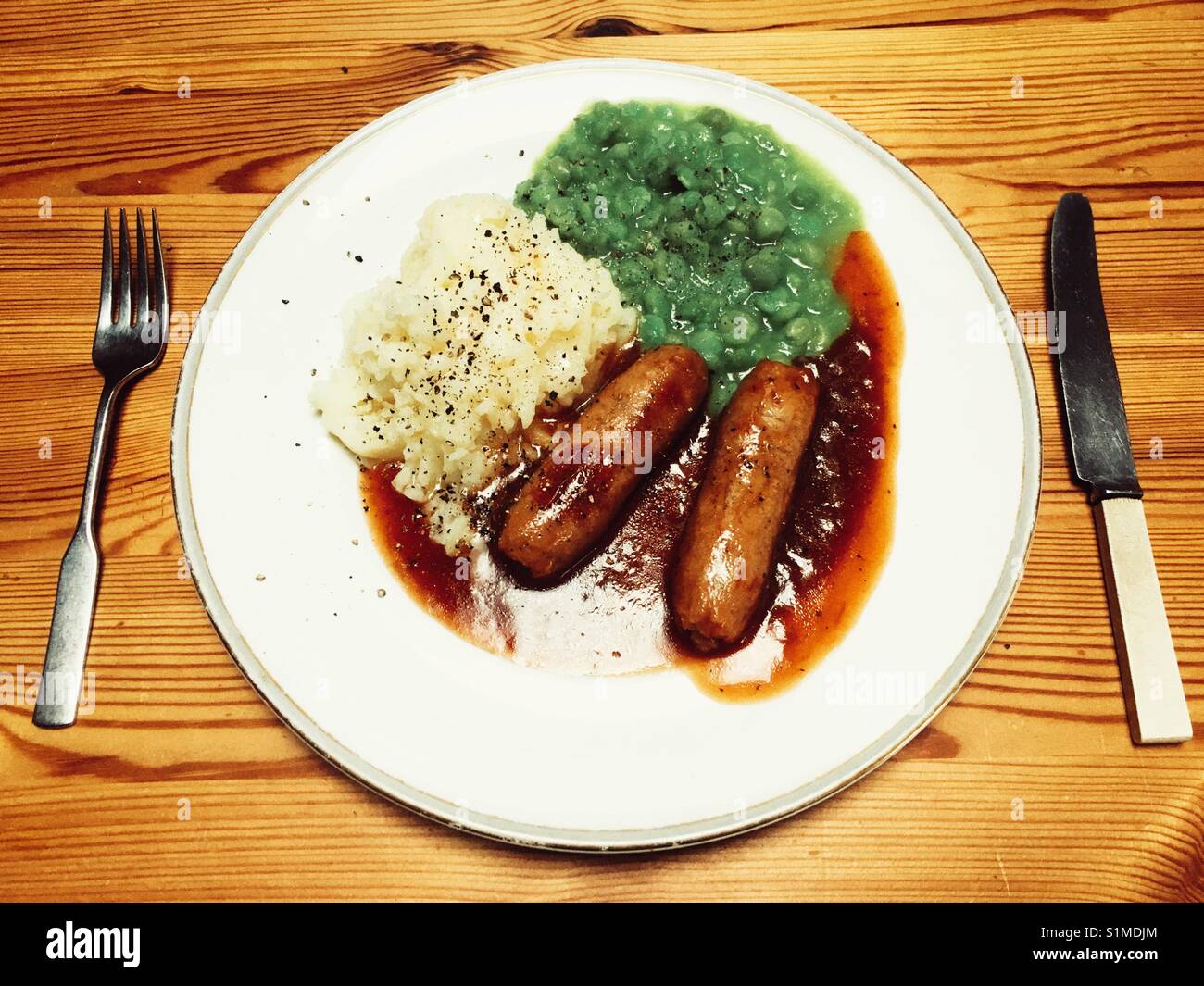Wurst, Brei und Erbsenpüree mit Zwiebel Sauce - Smartphone-aufgenommenes Stockfoto