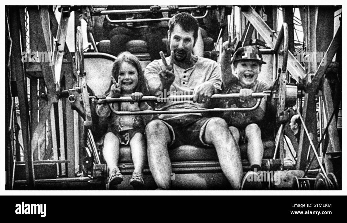 Mann und seine Kinder auf ein Riesenrad. Stockfoto