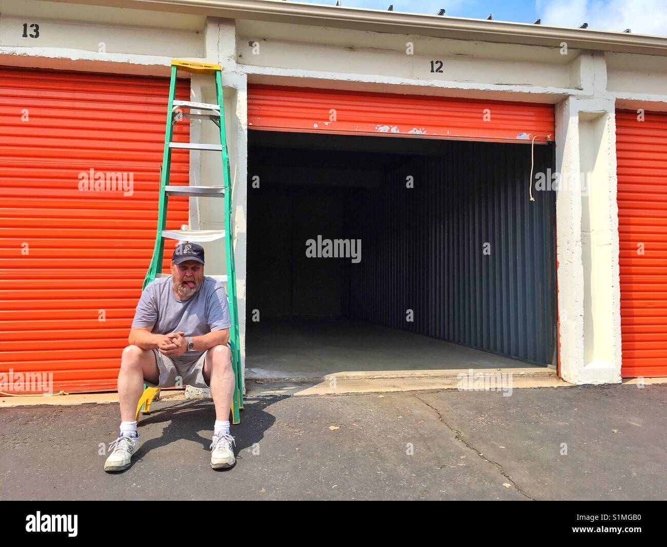 Ein Mann mit Zunge, Tor von einem leeren Speicher zu öffnen. - Smartphone-aufgenommenes Stockfoto