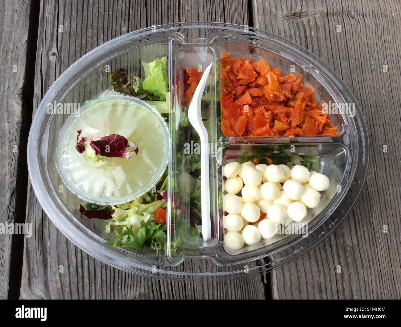 Nehmen Sie Nudelsalat mit Mozzarella in transparentem Kunststoff tellerförmigen Container Stockfoto