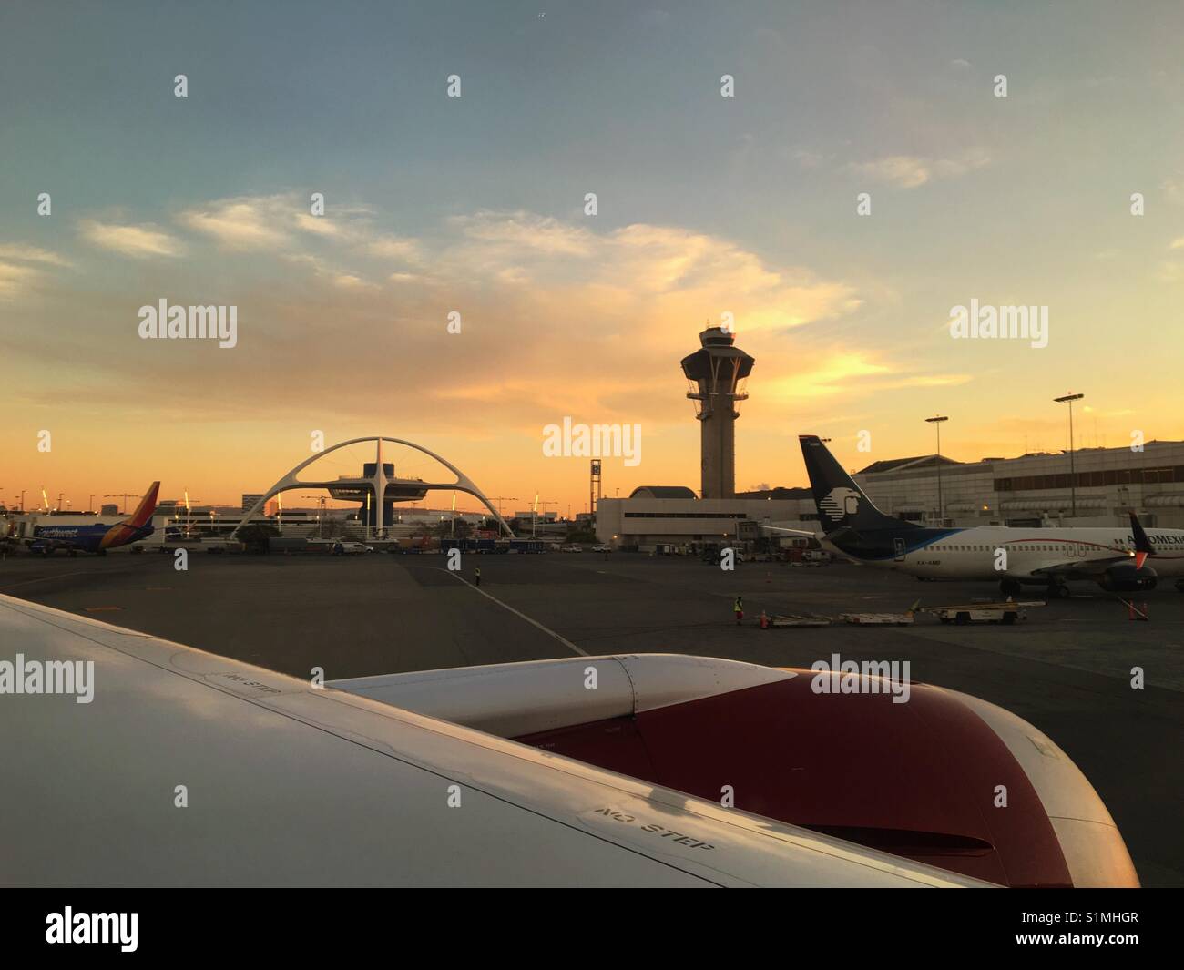 März 2017 - wieder über das Terminal Flughafen Los Angeles bei Sonnenuntergang mit Silhouetten von ikonischen Struktur des Flughafens und der Tower abzuweichen. Stockfoto