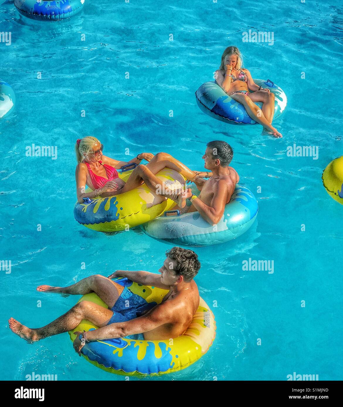 Sommer Urlaub - Sitzen und Liegen im Inneren aufblasbare Plastikringe & Relaxen in einem Wellenbad. Foto - © COLIN HOSKINS. - Smartphone-aufgenommenes Stockfoto