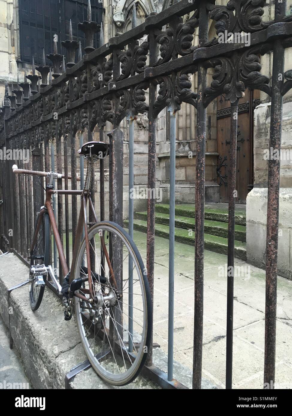 Alten rostigen Fahrrad gegen ein Wire gate Schiefen Stockfoto