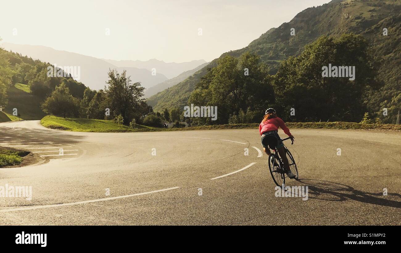 Frau Radfahren Absteigend a Mountain Road Stockfoto