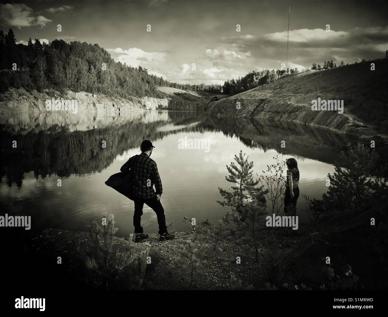 Mann und der Junge auf der Suche über noch schwedischen Steinbruch See Stockfoto