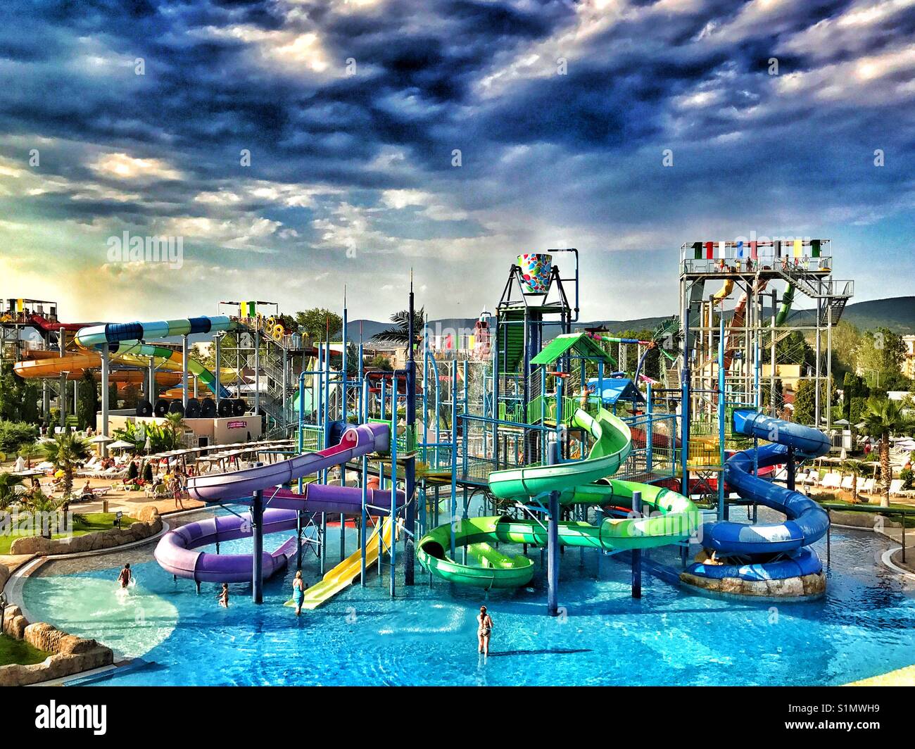 Gewitterwolken zusammenbrauen über einen großen Wasserpark mit zahlreichen und vielfältigen Wasserrutschen. Es ist Sommer und die Leute sind im Urlaub. Foto - © COLIN HOSKINS. - Smartphone-aufgenommenes Stockfoto