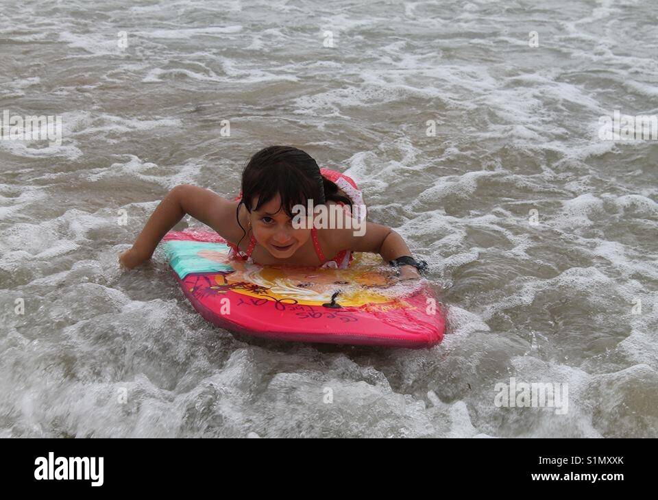 Kleines Mädchen surfen in Wellen, South Coast NSW Australien Stockfoto
