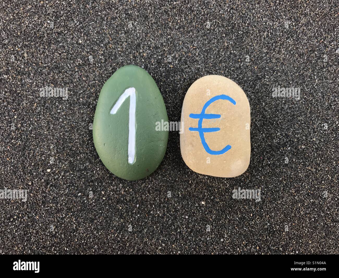 1 Euro mit geschnitzten und farbigen Steinen Stockfoto