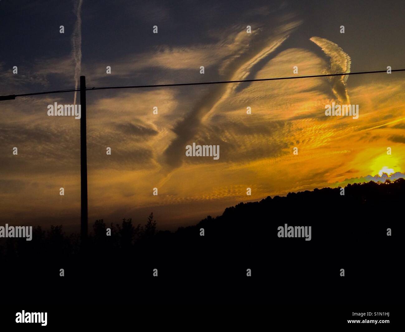 Kondensstreifen und Rillen in Golden Sky über North Carolina Feld Stockfoto