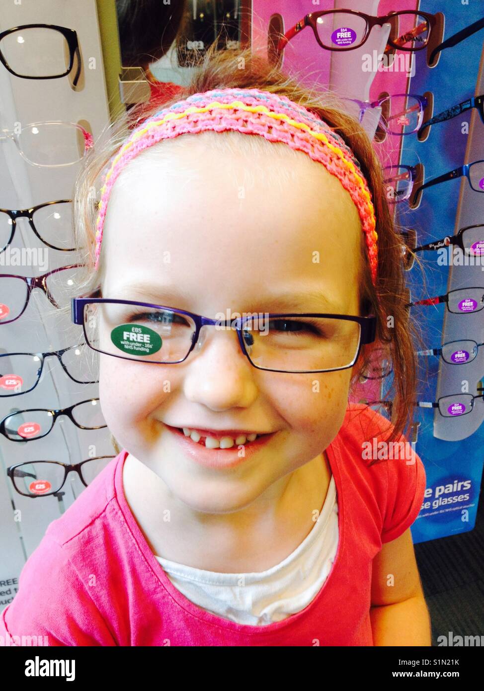 Fünf Jahre altes Mädchen versucht, neue Brillen / Brille bei einem Optiker zu speichern. Stockfoto