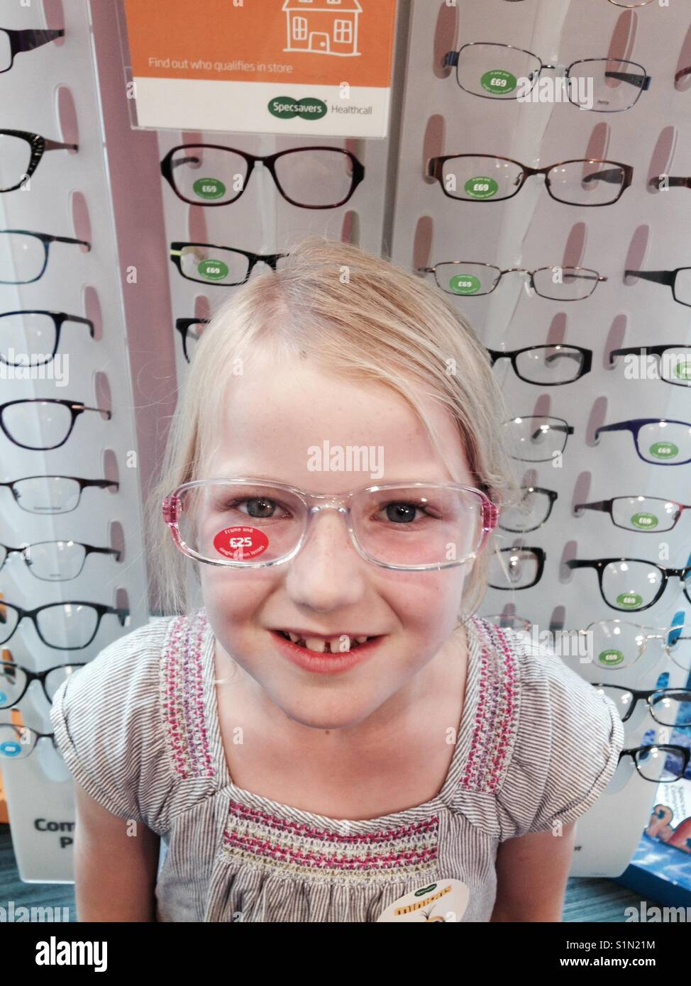 Sieben Jahre alten Mädchen versucht, neue Brillen / Brille bei einem Optiker zu speichern. - Smartphone-aufgenommenes Stockfoto