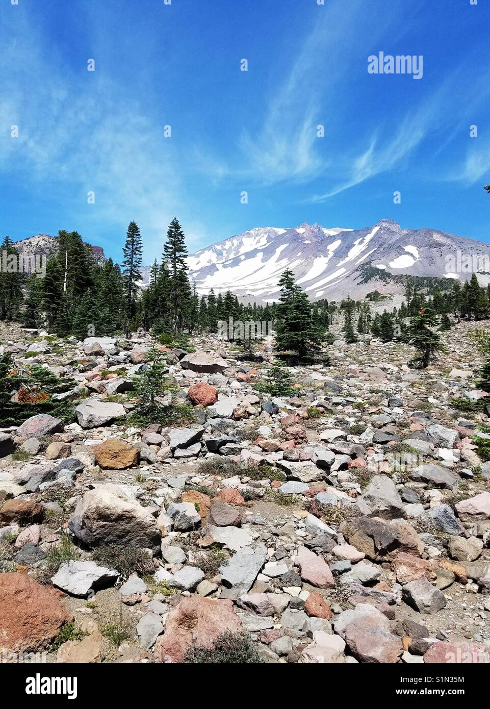 Nähert sich der Gipfel des geheimnisvollen Mount Shasta, diese vertikale Format verfügt über einen großen Stein Geröll Feld im Vordergrund. Stockfoto