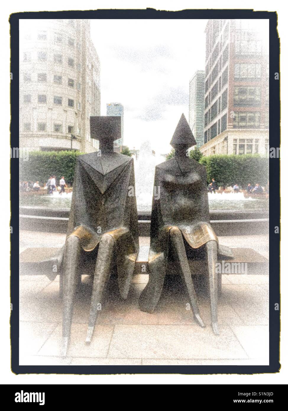 Paar Statuen sitzt auf der Bank am Canary Wharf in London. Stockfoto