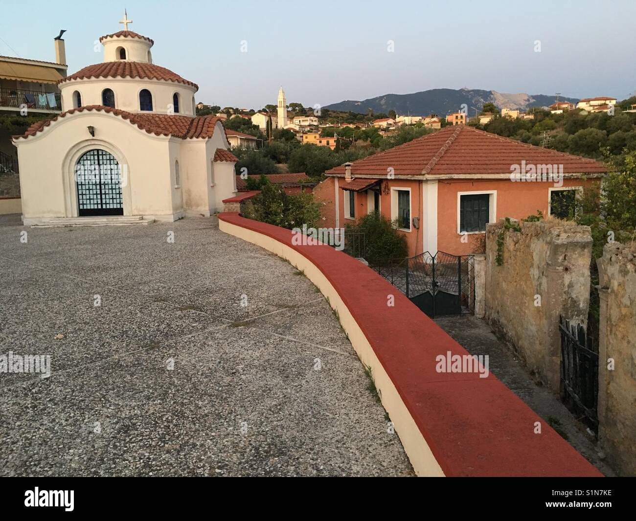Kirche der Panagia Theotokos und Blick in ein altes und ein neues Haus mit Metacara im Hintergrund auf Kefalonia in Griechenland - Smartphone-aufgenommenes Stockfoto