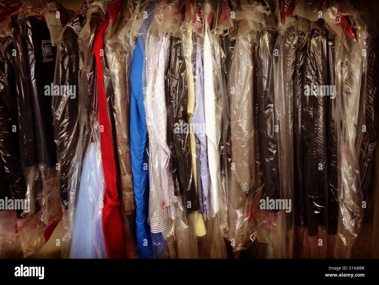 Trocken gereinigt Kleidung auf einer Schiene Stockfoto