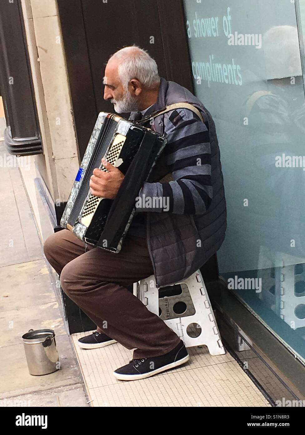Mann spielt Klavier Akkordeon außerhalb M&S Kensington London Stockfoto