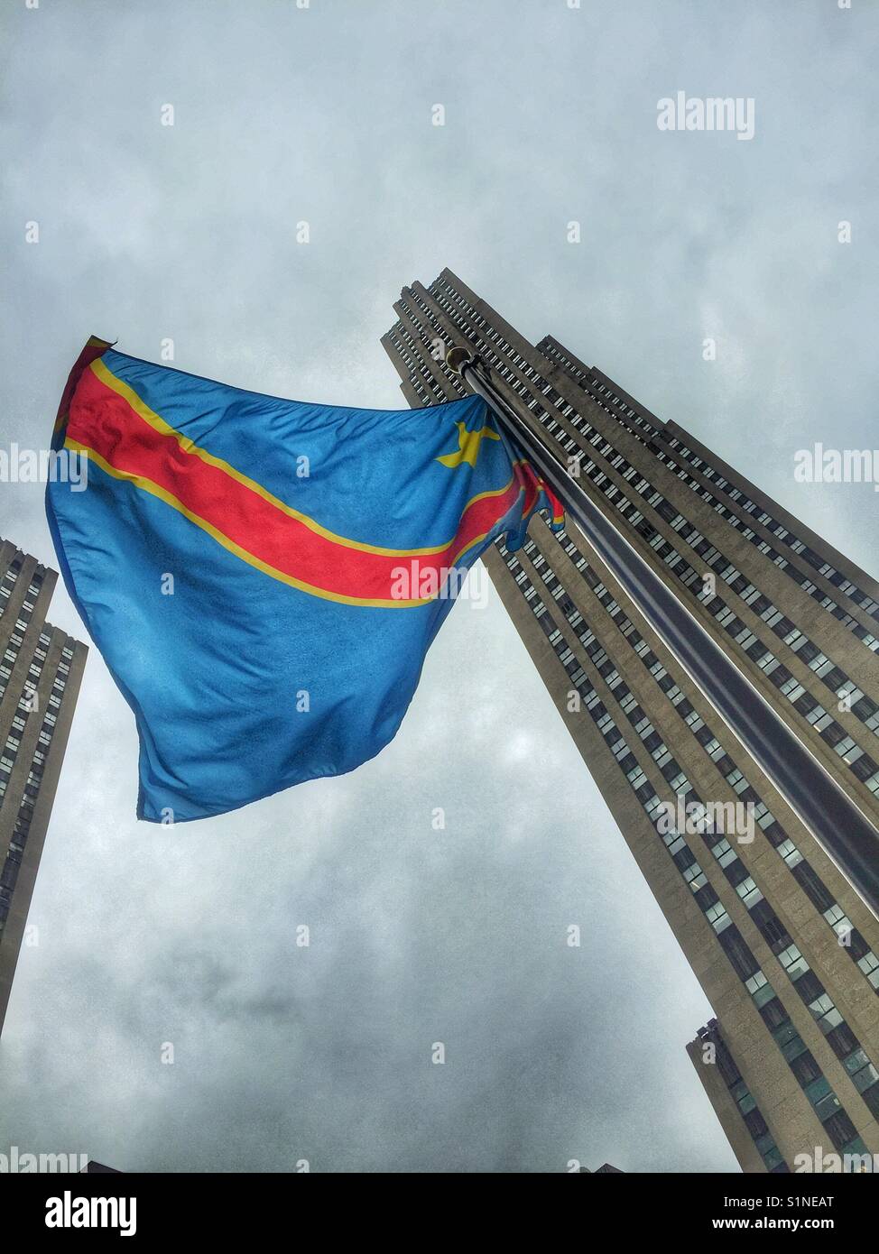 Die Flagge der Demokratischen Republik Kongo fliegt am Rockefeller Center Rockefeller Gebäude im Hintergrund, New York City, New York. Stockfoto
