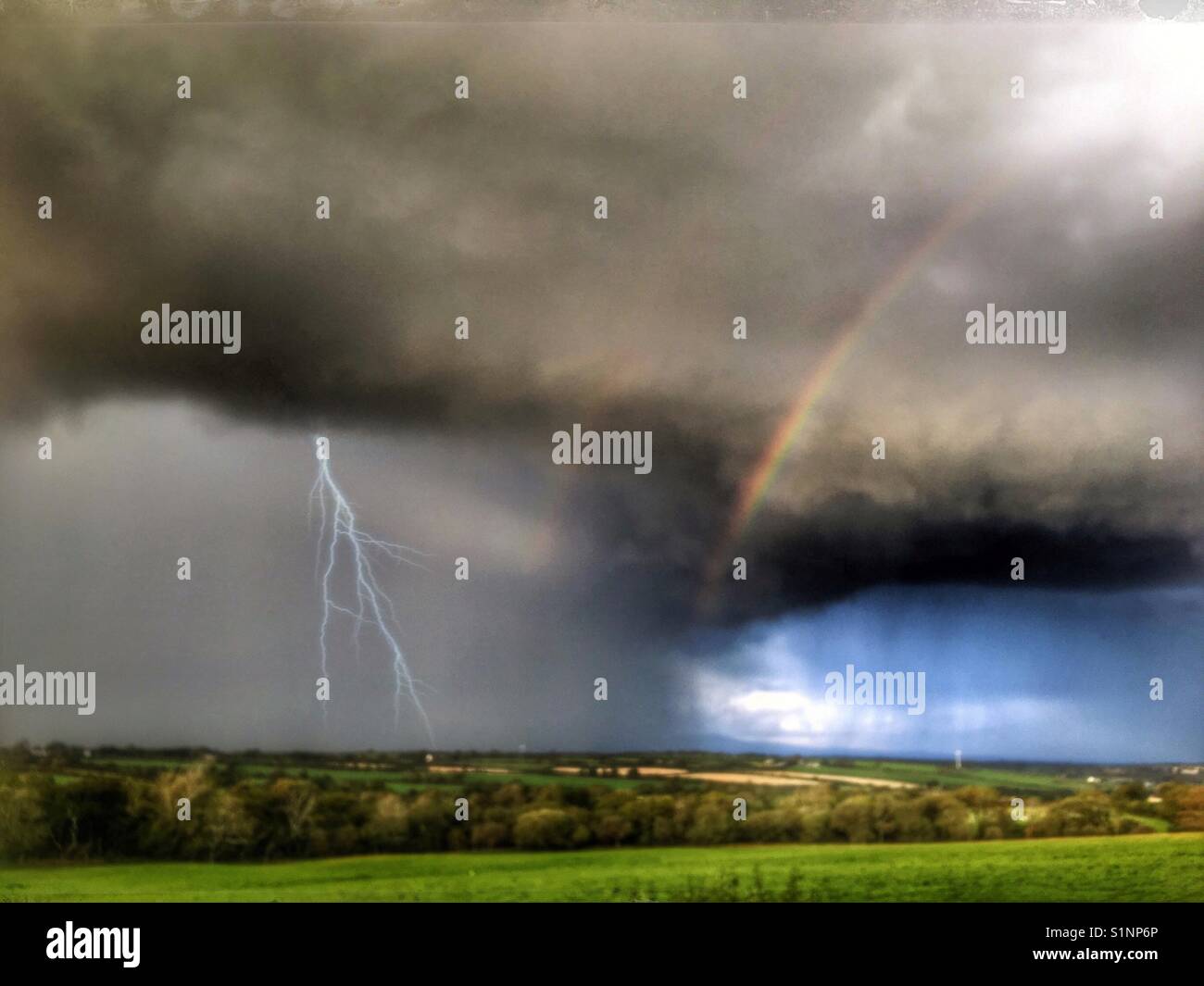 Wetter vorne mit Regenbogen, Sonne, Regen und Blitz Stockfoto