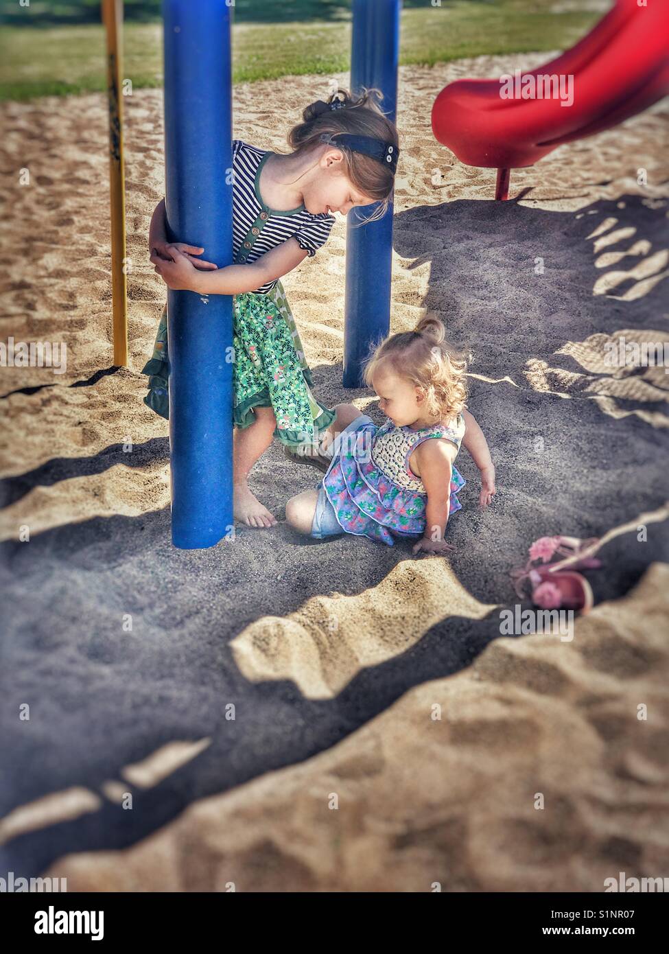 Schwestern spielen im Park im Sand Stockfoto