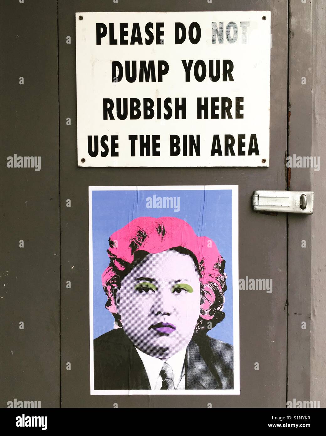 Street Art Poster unter einem Mülleimer Zeichen Stockfoto