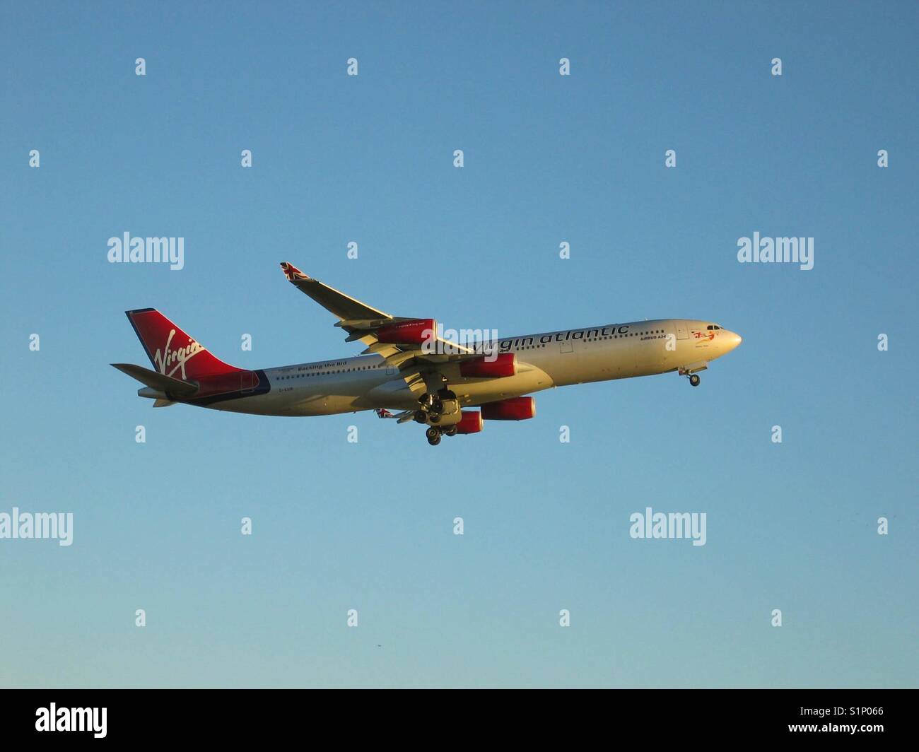 Virgin Atlantic Airbus A340, die in der untergehenden Sonne Stockfoto