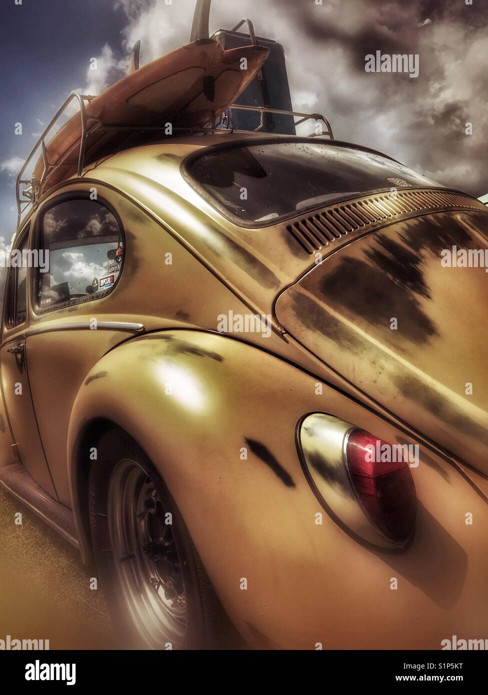 Gelber Vintage Volkswagen Käfer mit Surfbrettständer - Smartphone-aufgenommenes Stockfoto
