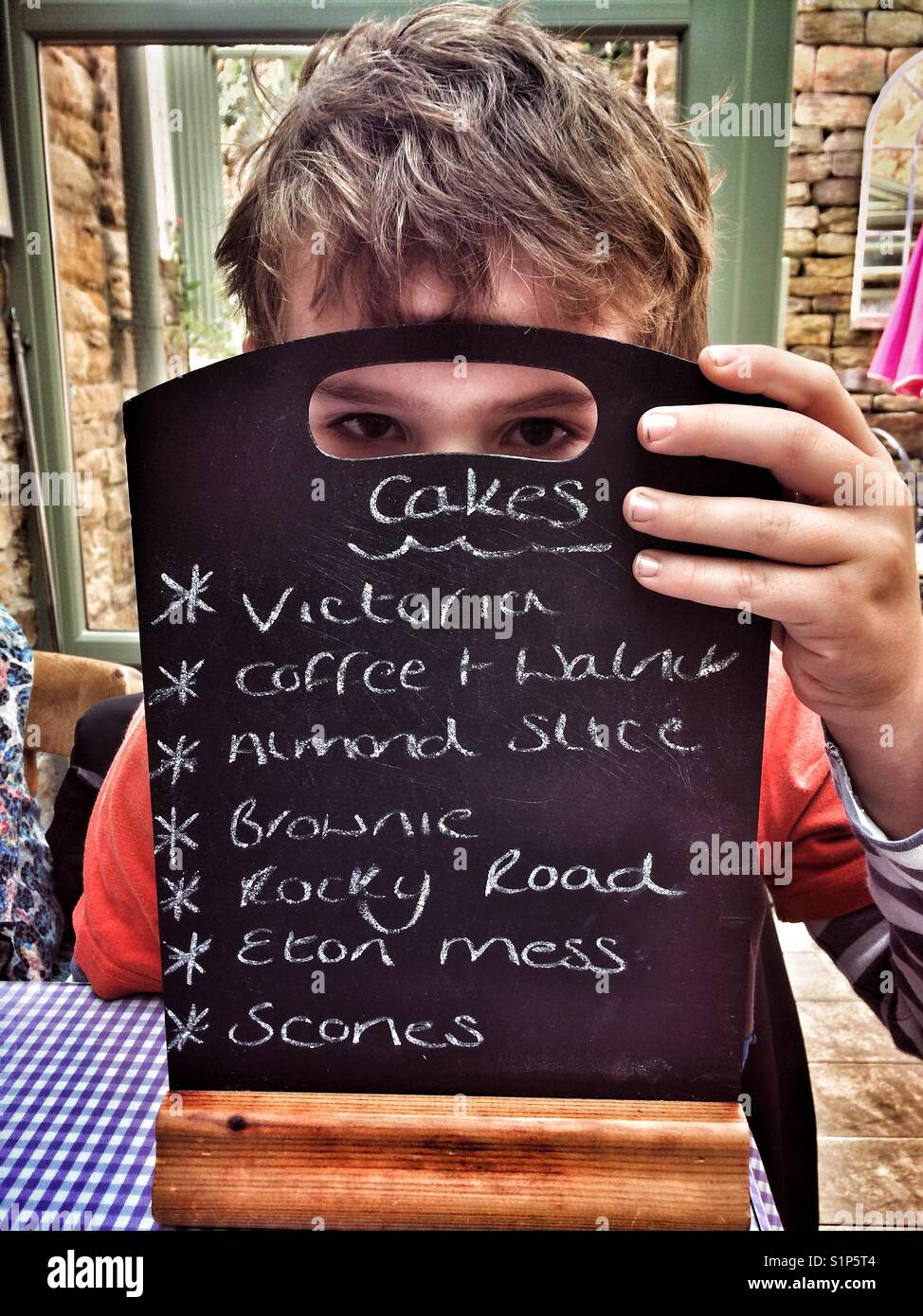 Junge acht Jahre mit Kuchen Menü Stockfoto