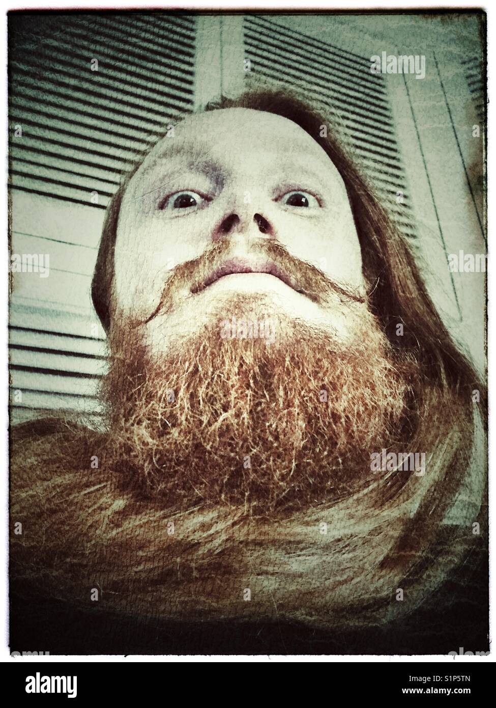 Mann mit dem langen Haar aufgewickelt um wie ein Schal. - Smartphone-aufgenommenes Stockfoto