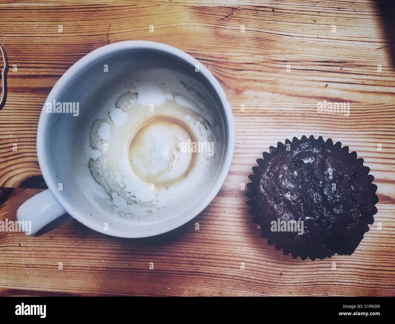 Chocolate Muffin und eine leere Kaffeetasse. Stockfoto