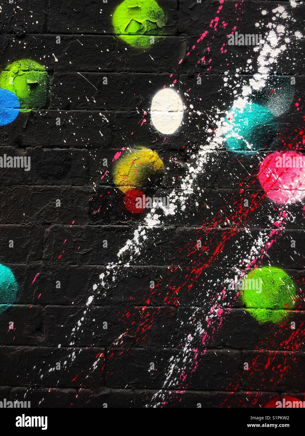 Farbenfrohe Graffiti-Kunstwerke an einer Ziegelwand - Smartphone-aufgenommenes Stockfoto