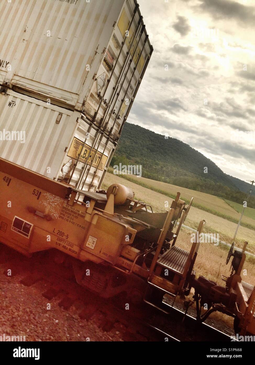 Eine Eisenbahn Güterwagen auf der Bahn mit einem offenen Feld im Hintergrund Stockfoto