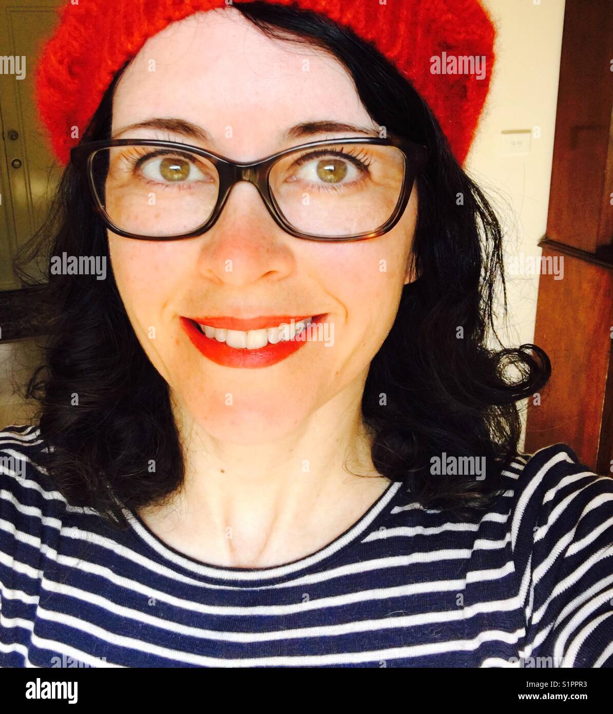 Frau mit Hut und Brille lächelnd Stockfoto