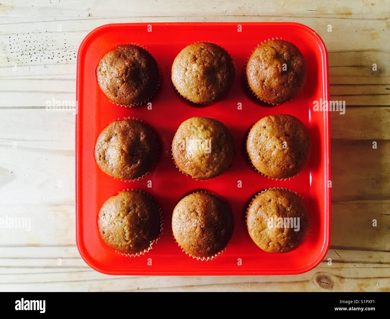 Hausgemachte Zucchini-Muffins in einem roten Plastiktablett - Smartphone-aufgenommenes Stockfoto