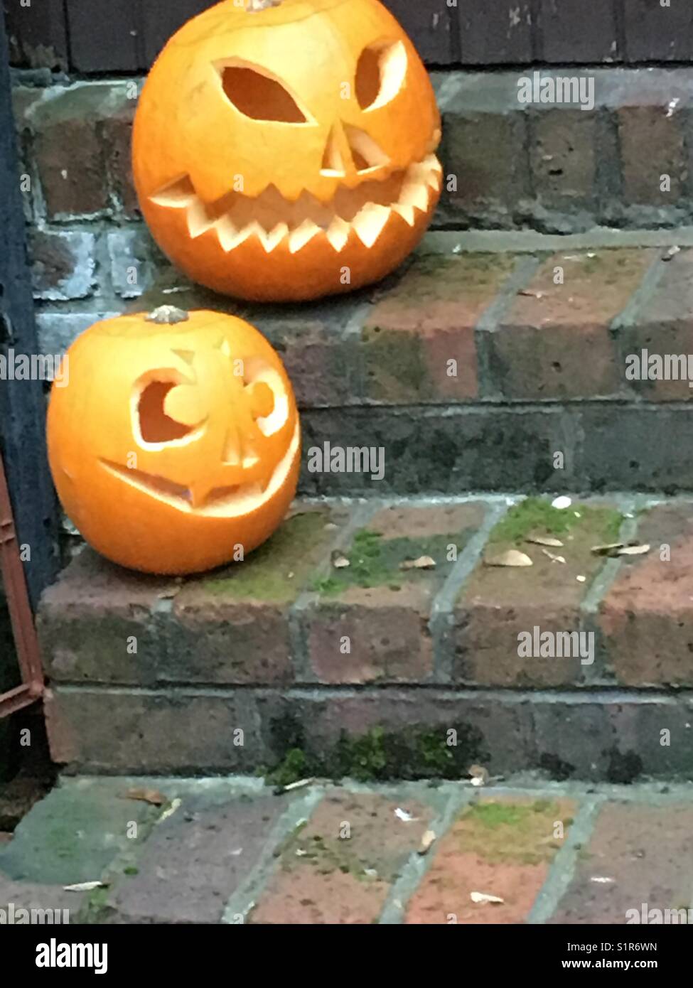 Geschnitzter Kürbis, bereit für Halloween vor der Haustür - Smartphone-aufgenommenes Stockfoto