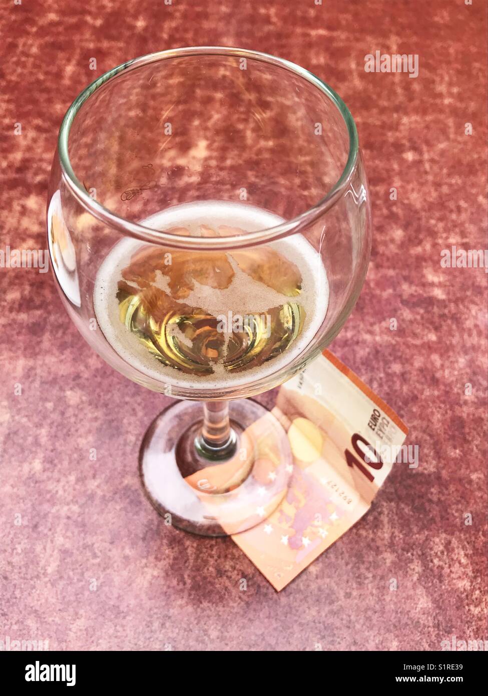 Leeres Glas Bier und zehn Euro beachten. Stockfoto