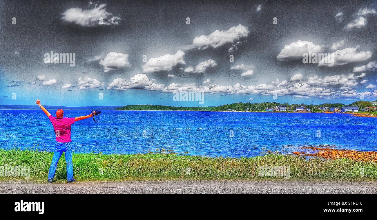 Rückansicht der Mann mit ausgestreckten Armen durch das Meer Stockfoto