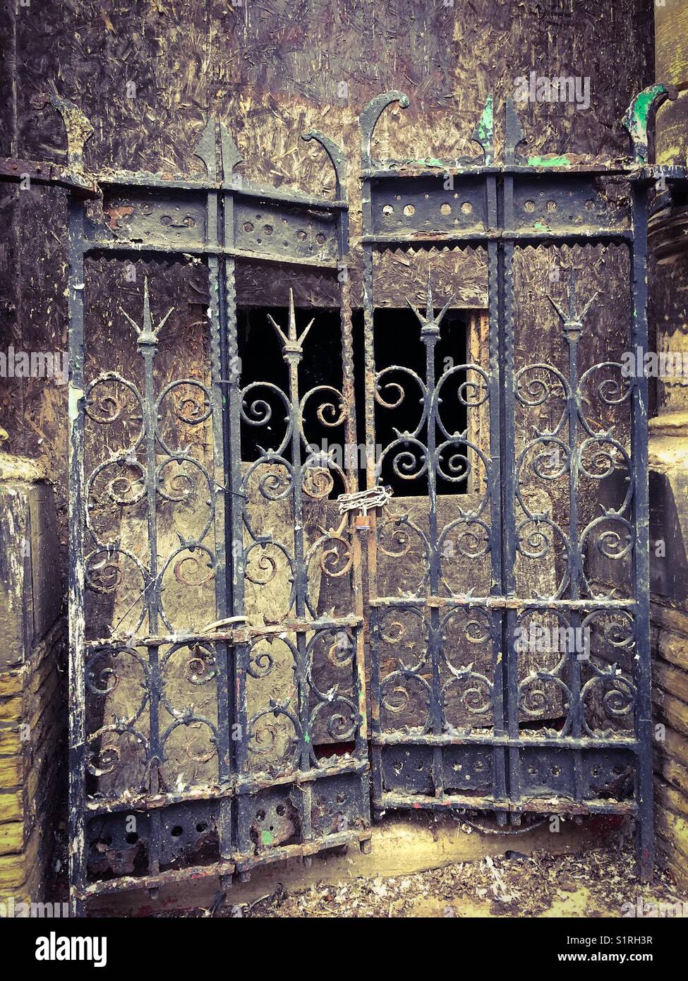 Gesperrt, rostigen alten schmiedeeisernen Toren sperren den Weg in einem leerstehenden Gebäude - Smartphone-aufgenommenes Stockfoto
