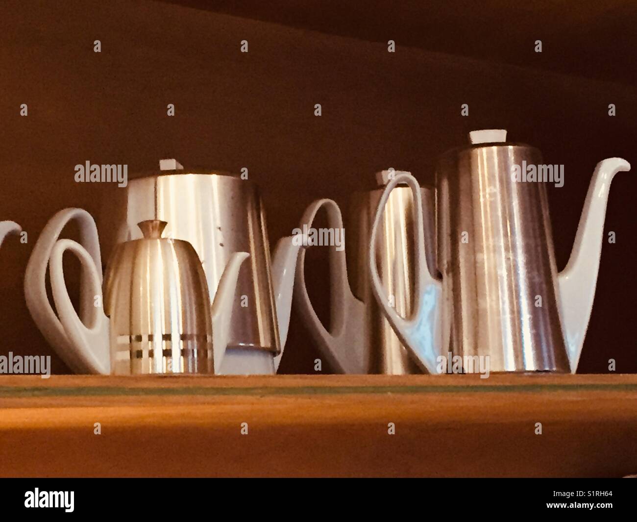 Art Deco metall Kaffee Set à 4 Stück im Regal mit keramischen Griffe und Trinkschnäbel vor einem schwarzen Hintergrund Stockfoto