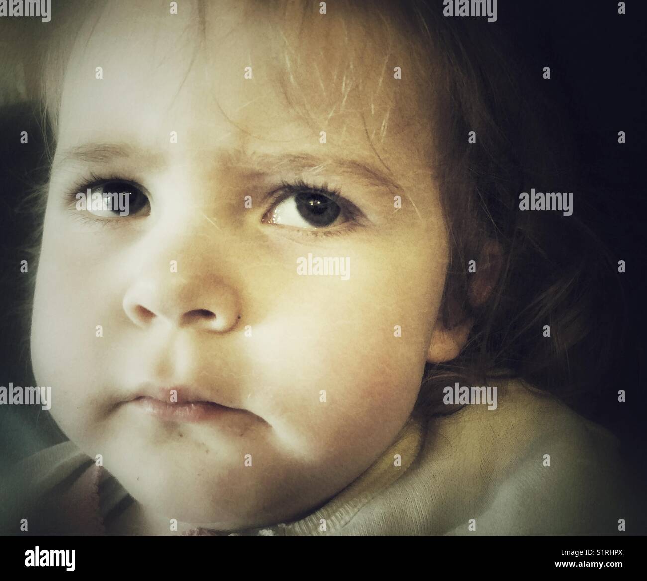 Moody closeup von Toddler girl Gesicht mit ängstlichen Ausdruck oben und an der Seite Stockfoto