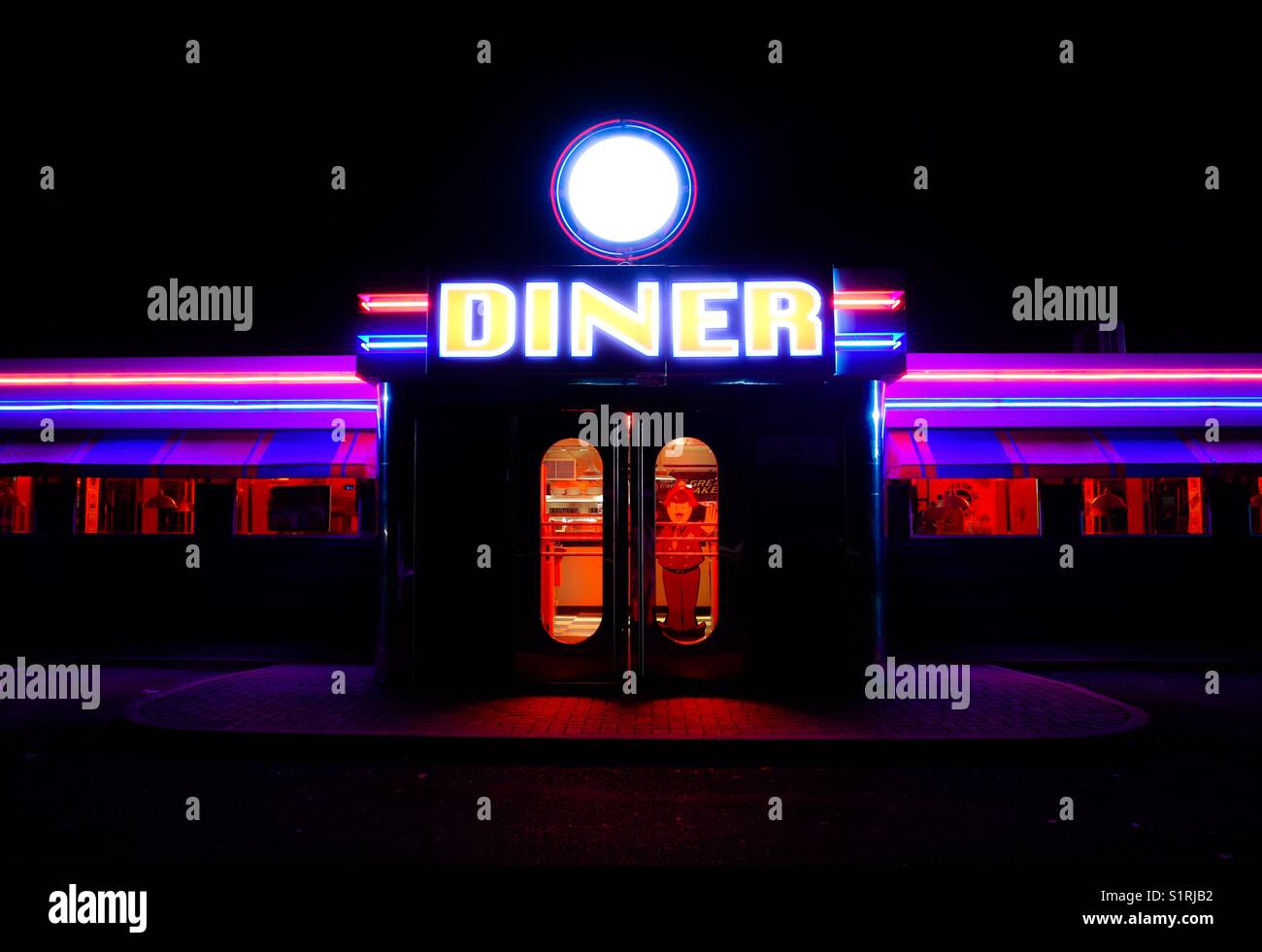 Die Tür und helles Neon Schild vor dem eines traditionellen American Diner in der Nacht. Stockfoto