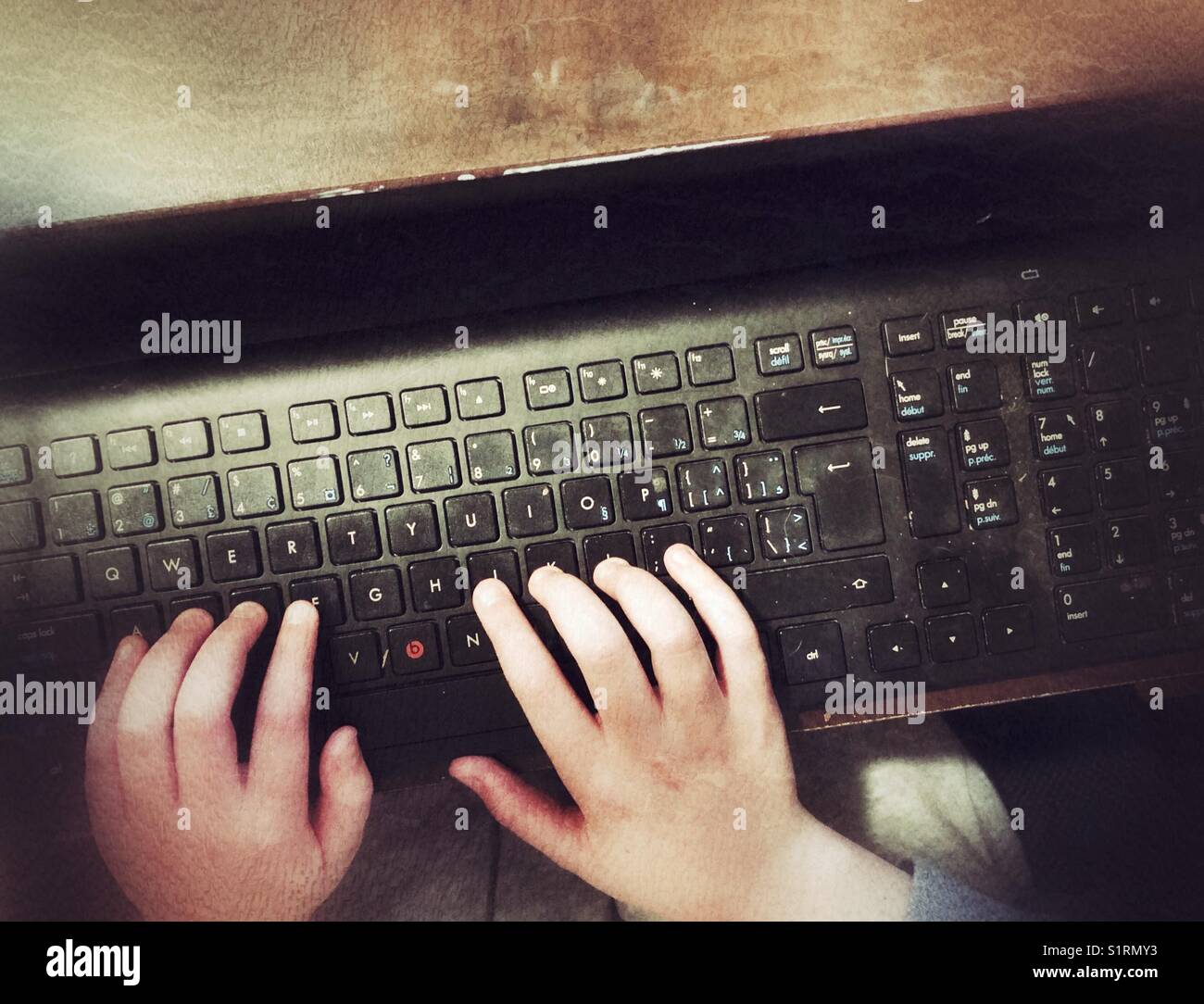 Kind Hände schreiben auf einer persönlichen schwarz computer Tastatur Stockfoto