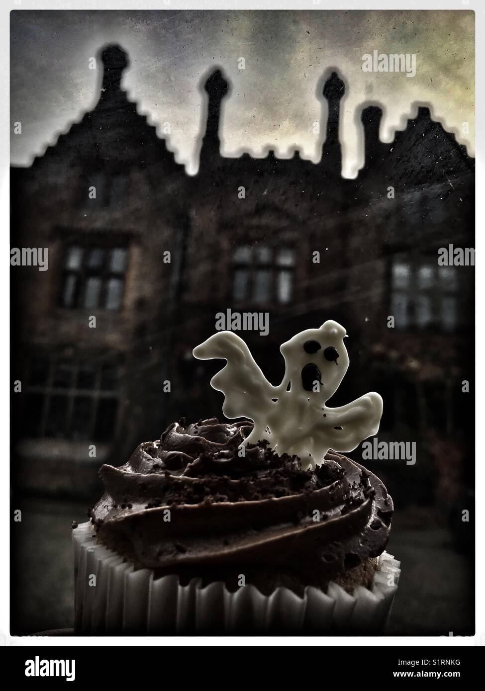 Geisterhafte Cupcake vor einem gruseligen alten Gebäude. Stockfoto