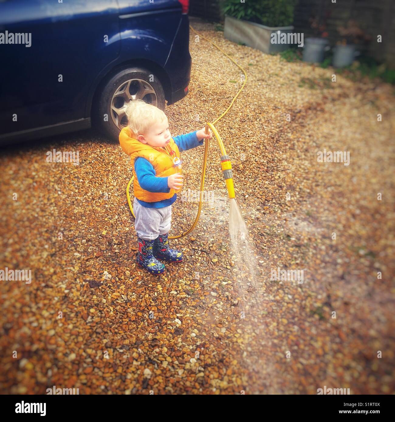 Ein Jahr alten Jungen helfen, das Auto waschen Stockfoto