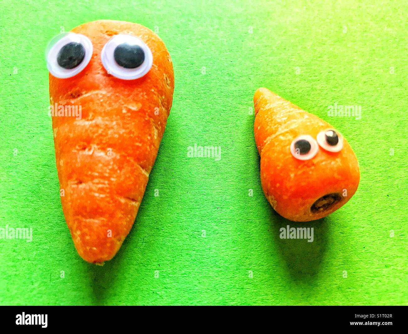 Kleine orange Karotten mit Googley-Augen - Smartphone-aufgenommenes Stockfoto