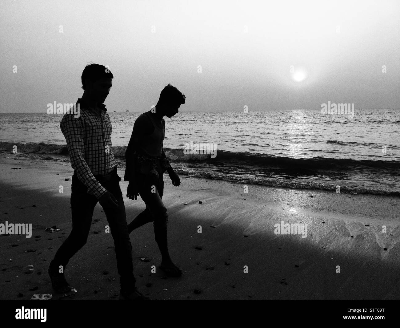Freunde Spaziergang bei Sonnenuntergang in Juhu Strand von Mumbai Stockfoto