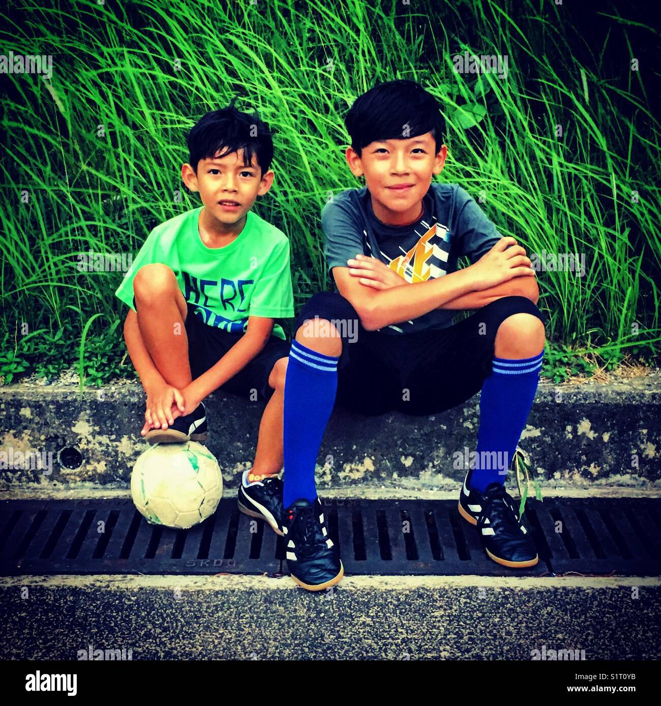 2 Jungs Fußball playets mit einer Kugel stellen - Smartphone-aufgenommenes Stockfoto