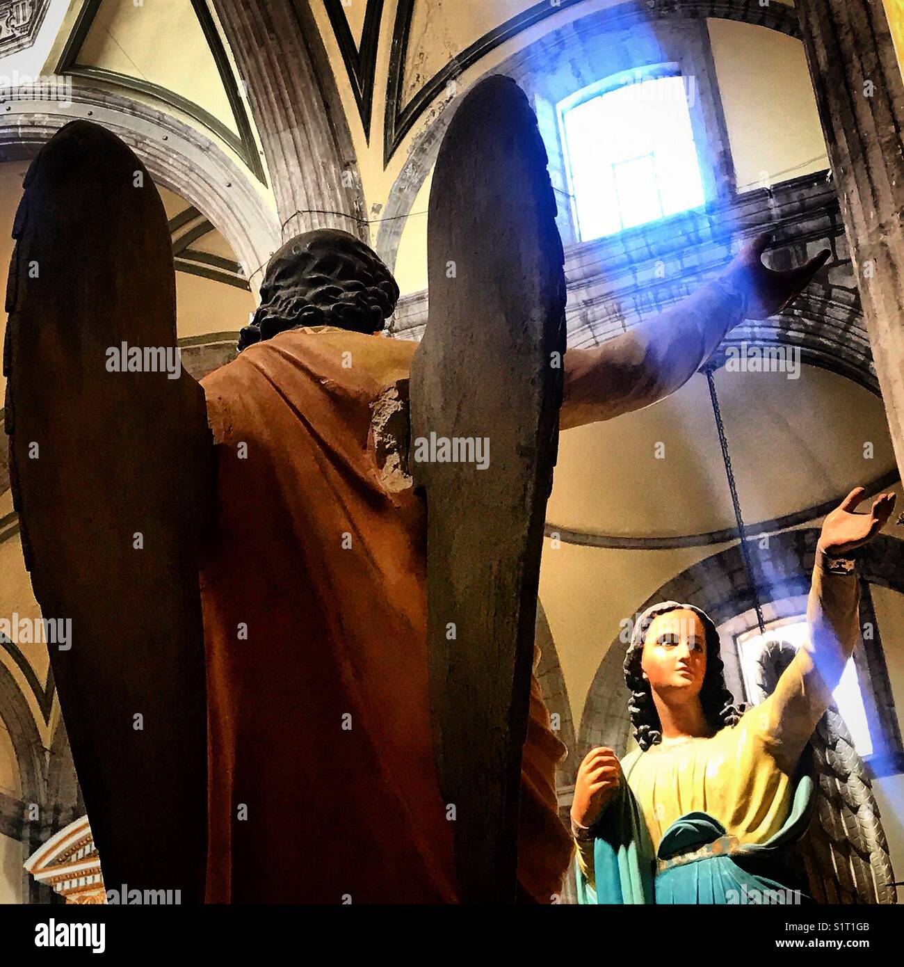 Engel Skulpturen werden durch einen blauen Strahl des Sonnenlichts in der Metropolitan Kathedrale in Mexiko City, Mexiko beleuchtet Stockfoto